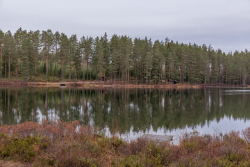 Fototapeta na wymiar Autumn landscape. Sweden. Lake, calm water, forest reflection in the water clouds