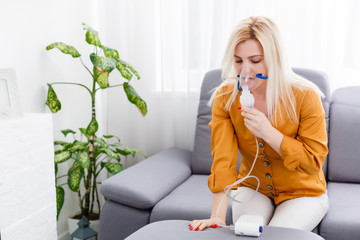 Portrait of adult woman using steam vapor inhaler nebulizer doing aerosol inhalation medicine treatment at home or hospital flu and asthma bronchitis virus healing - obrazy, fototapety, plakaty