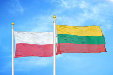 Poland and Lithuania two flags on flagpoles and blue cloudy sky