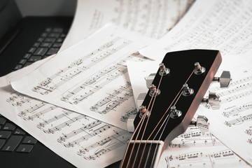 close up of guitar neck and note sheet and notebook - selective focus