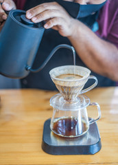 Barista pours water into the filter with coffee