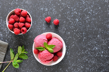 Raspberry ice cream scoop with fresh raspberries and fresh berry in bowl