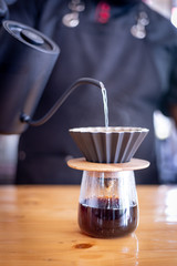 Barista pours water into the filter with coffee