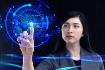 Business, Technology, Internet and network concept. Young businessman working on a virtual screen of the future and sees the inscription: Outsourcing