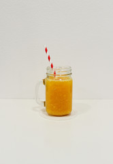 glass of orange juice with paper straw vertical