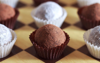 Energy balls on a chessboard. Sweets proper nutrition. Made from dates, oatmeal, peanuts, coconut.