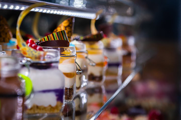 Fototapeta na wymiar Kolorowe ciastka i desery na ladzie cukierniczej 