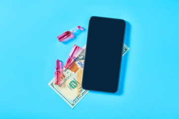 Smartphone near red vaccine and banknote of one hundred dollars on blue background. E-health, e-medicine, payment for services concept. Online purchasing, consultation, medical assistance