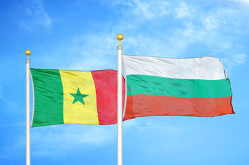 Senegal and Bulgaria  two flags on flagpoles and blue cloudy sky