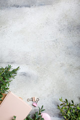 Women's workplace. Notepad and flowers on gray background, copy space.