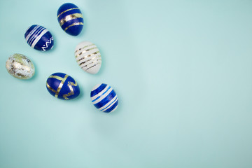 Colorful border of blue and white Easter eggs on the blue background. Top view. Flat lay