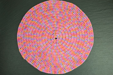handmade multicolor crochet background in orange, pink and purple with spiraling double crochet stitches
