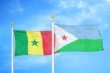 Senegal and Djibouti two flags on flagpoles and blue cloudy sky