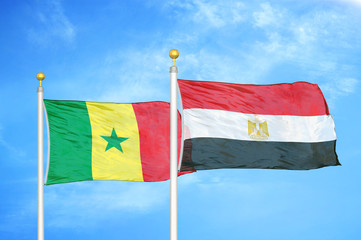 Senegal and Egypt two flags on flagpoles and blue cloudy sky