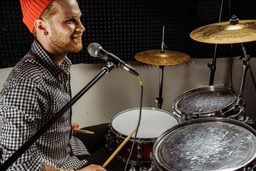 gorgeous talented caucasian singer play on drums and sing his favourite song, rocker man love his job, musician in recording studio, enjoy