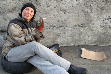 Homeless dirty woman with a cigarette in her hands