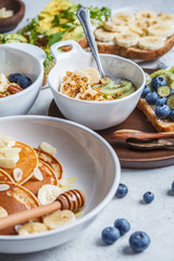 Oatmeal with fruits, chia pudding, pancakes with banana  and toasts with fruits, vegetables and cream cheese.