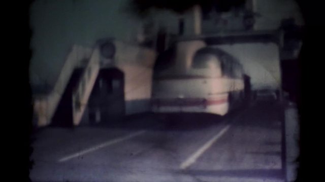 A bus enters the ship. Film runs through an 8mm projector