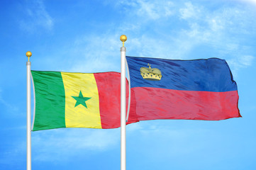 Senegal and Liechtenstein two flags on flagpoles and blue cloudy sky