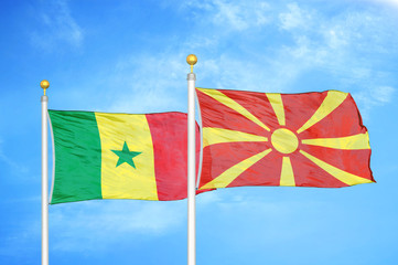 Senegal and North Macedonia two flags on flagpoles and blue cloudy sky