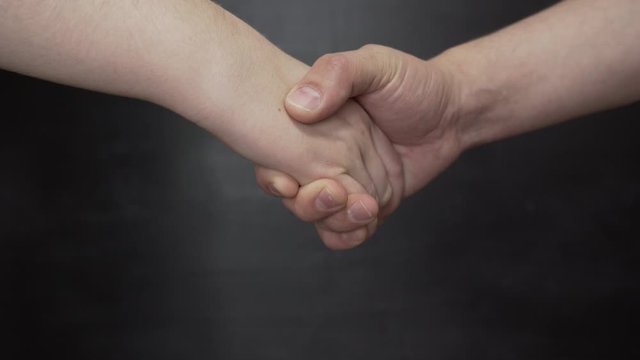 handshake of a man and a woman on a black background