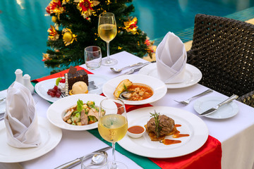 Luxury romantic dinner set up by the pool for couple on Christmas eve event.