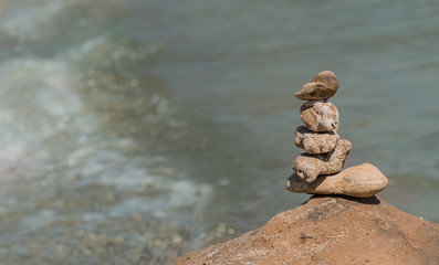 Zen concept. Object made of stone on the beach. Stone pyramid for meditation. Harmony and Meditation. Zen stones.