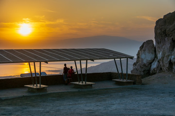 Family admiring a beautiful sunrise on the dead sea.