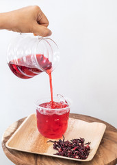 Ice roselle juice isolated on wooden tray and white background.