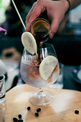 Close up hand of barista pouring esspresso coffee in to lime soda.