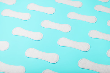 Many Sanitary pads on a blue background in the form of a diagonal pattern. Textured background all over the screen.