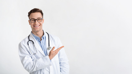 Smiling doctor in coat points to free place