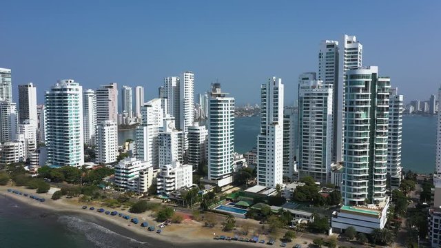 Aerial View of the hotels and tall apartment buildings near the Caribbean coast. Modern City Skyline. Free span of the camera in space. The camera moves back from the object.