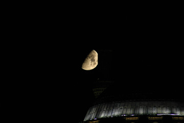 A mosque and moon at night.