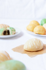 gefüllte bunte und farbige Eier aus Hefe mit Zuckerguss zu Ostern auf Teller auf weißer Decke