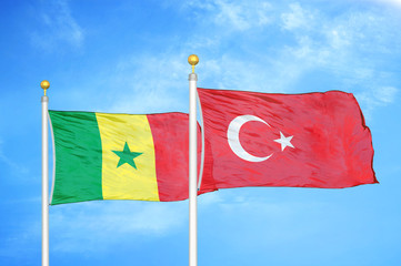 Senegal and Turkey two flags on flagpoles and blue cloudy sky
