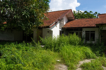 Fototapeta na wymiar Abandoned house with overgrown grass.