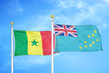 Senegal and Tuvalu two flags on flagpoles and blue cloudy sky