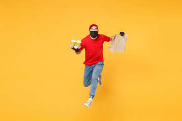 Fototapeta na wymiar Fun jumping delivery man guy employee in red cap mask gloves hold craft paper packet food coffee isolated on yellow background studio. Service quarantine pandemic coronavirus virus 2019-ncov concept.