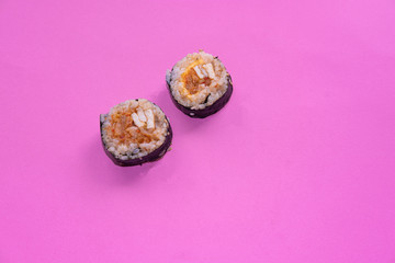 Kimbap rolls made with kimchi on a pink background. Korean cuisine. Conceptual. Top view.