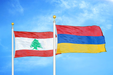 Lebanon and Armenia  two flags on flagpoles and blue cloudy sky