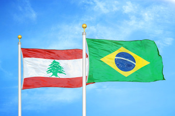 Lebanon and Brazil  two flags on flagpoles and blue cloudy sky