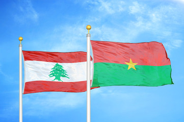 Lebanon and Burkina Faso  two flags on flagpoles and blue cloudy sky
