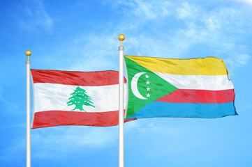 Lebanon and Comoros two flags on flagpoles and blue cloudy sky