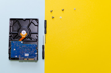 hard drives and screwdrivers on yellow background