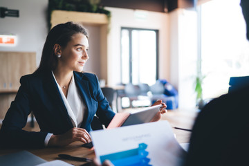 Thoughtful female entrepreneur pondering looking away while male colleague analyzing revenue analytics, collaboration process of business people during brainstorming meeting in corporate company