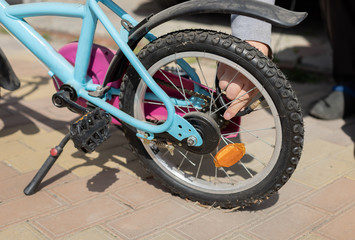 male hands pump up the wheel on a children's bike. Pumping air into a bicycle wheel. close-up