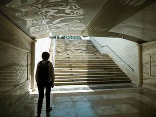 Rear view of single tourist woman with backpack walking exiting Marble underground in central Baku , Azerbaijan