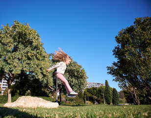 girl jumping happy in the park freedom concept