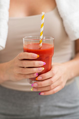 Woman drinking tomato smoothie after fitness workout